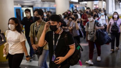 全球各地逐渐放宽防疫准则，周二在菲律宾马尼拉的奎松市，从地铁站出来的乘客们戴著口罩，做好防疫措施。（图取自路透社）