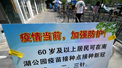 北京市一处核酸检测点，张贴有提示60岁及以上居民接种新冠疫苗的告示。（图取自中新社）