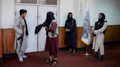 阿富汗首都喀布尔，塔利班最高领袖阿洪扎达周六就新的头巾令召开记者会，现场可见塔利班战士站岗。（图取自路透社）