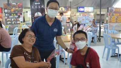 刘华才（左2）周日前往Icon City大家发饮食中心，派送康乃馨予民众。