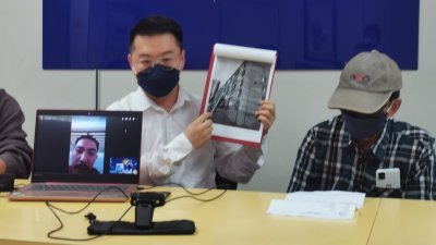 阿明通过视讯电话接受访问外，其父亲阿兴（右）也在刘国南（左）的陪同下现身新闻发布会现场。