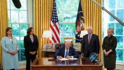 美国总统拜登当地时间周一在白宫椭圆形办公室，签署国会早前通过的乌克兰版《租借法案》。（图取自路透社）