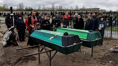 乌克兰基辅市郊的布查镇，民众参加在战争中遇难的家属的葬礼。（图取自路透社）