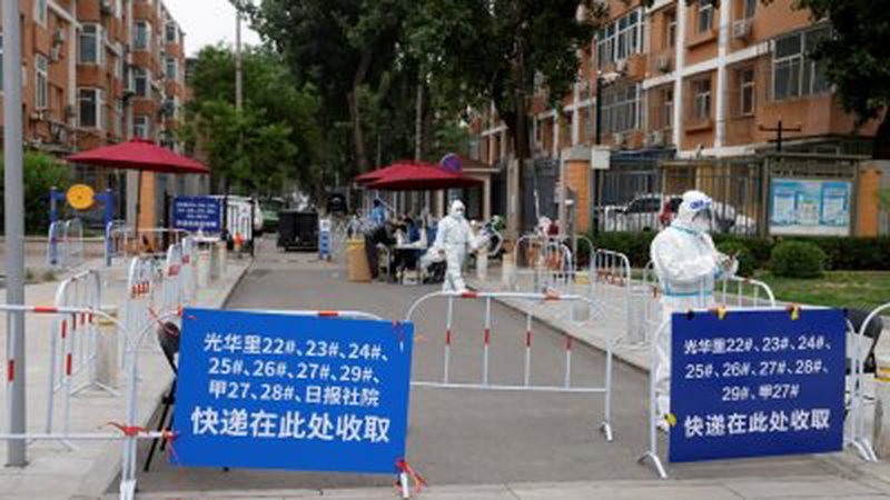 中国北京市疫情仍未好转，周二一处被管制出入的住宅区可见身著防护服的防疫人员正在走动。（图取自路透社）