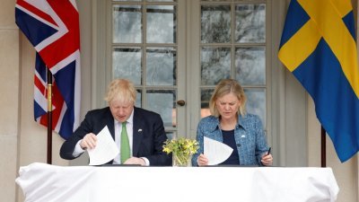 英国首相约翰逊（左）和瑞典首相安德松签署政治宣言，加强军事等领域的双边合作。（图取自TT News Agency/路透社）