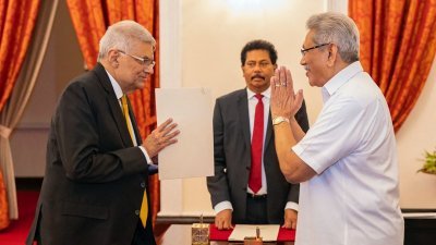 维克勒马辛哈（左）周四在斯里兰卡总统府，在总统（右）主持下宣誓就职新任总理。（图取自斯里兰卡总统府/法新社）