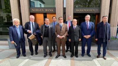阿邦佐哈里（中）在挪威与该国银行投资管理部官员会面后，与官员们合影留念。