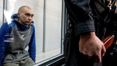 21岁的俄罗斯士兵希希马林，坐在法庭内玻璃隔开的被告席上受审。（图取自路透社）