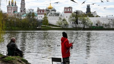 图为民众5月6日在莫斯科新圣女修道院旁的公园湖边钓鱼。（图取自法新社）
