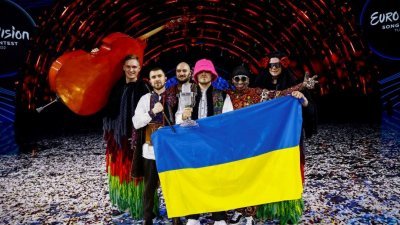 代表乌克兰参赛的卡卢什管弦乐团在夺得冠军后，成员们手持乌克兰国旗拍照。（图取自路透社）