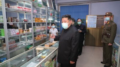 朝鲜官媒朝中社周一发布的照片显示，戴上口罩的最高领导人金正恩周日视察平壤一些药店，以了解医药品供应及销售情况。（图取自朝中社/法新社）