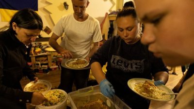 来自顿巴斯地区的难民在第聂伯罗“世界中央厨房”的难民收容所享用该组织提供的膳食。（图取自路透社）