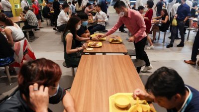 新加坡在4月26日起放宽防疫措施，社交聚会、堂食和家庭访客人数将不再设限。图为中央商业区的上班族，当天午休时间在外用餐。（图取自路透社）