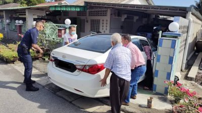 华裔老妇疑是换错排档，导致轿车撞及住家围墙，受困车内。（图取自和丰警区面子书）