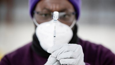 药剂人员在美国华盛顿一个大规模新冠疫苗接种点，用针筒抽取适量疫苗。（路透社档案照）