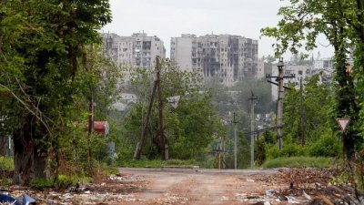 乌克兰卢甘斯克区的波帕斯纳镇，远处可见交战后遭毁损的公寓大楼。（图取自路透社）