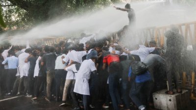 斯里兰卡警方于周日出动水炮，试图驱散意图闯入总统官邸的示威者。（图取自路透社）