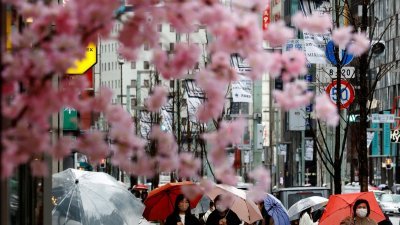 今年3月下旬，日本政府放宽了严苛的防疫准则后，民众依旧戴著口罩走在东京街道上。（路透社档案照）