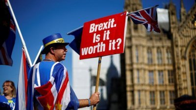 一名亲欧盟示威者手持写著“脱欧。值得吗？”的标语牌，于2018年9月在英国国会外抗议。（图取自路透社档案照）