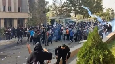 当局派遣安全部队进入大学校园逮捕学生示威者，图中的伊朗大学生正在躲避安全部队释放的催泪弹。（UGC/法新社）