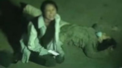 网上流传的视频中，女子跪在母亲身旁，痛苦呐喊。（图取自网络）