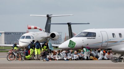 环保分子周立冲进荷兰首都阿姆斯特丹的史基浦机场私人飞机区，阻止飞机起飞长达数小时。（图取自路透社）