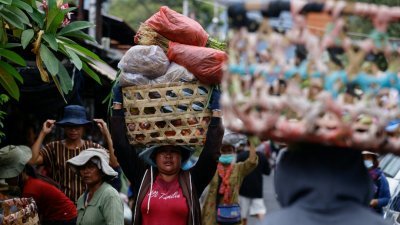 在巴厘岛登巴萨的一个市场上，妇女头上顶著装有水果和蔬菜的篮子。（图取自法新社）