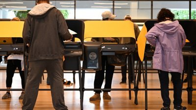 在加利福尼亚州洛杉矶哈默博物馆的一个投票中心内，部分选民们于当地时间周一在电子投票机上提早投票。（图取自法新社）