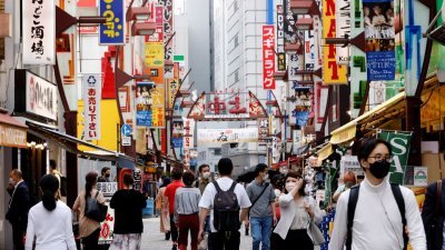 在日本东京阿美横商店街，民众都戴上口罩防疫。（图取自路透社）