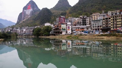 中国广西巴马是世界知名的长寿县，当地有个长寿村，村子临水而建，背面就是一座山，山上有一个大大的“寿”字。（图取自网络）