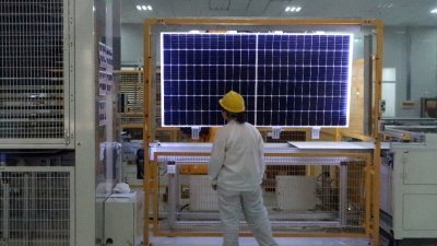 图为2017年，在中国陕西西安，太阳能设备制造商“隆基绿能”的一名工人对太阳能组件产品进行质量检查。（路透社档案照）