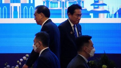 周六在柬埔寨金边举行的东盟会议上，日本首相岸田文雄（后右）和中国总理李克强（后左）擦肩而过。（图取自路透社）