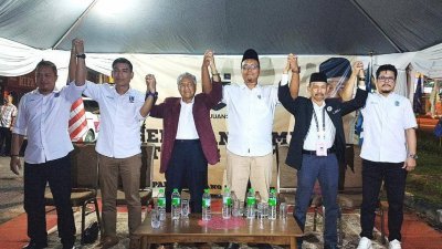 马哈迪（左3）举起5名甲州候选人的手，为他们打气。