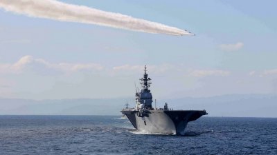 日本海上自卫队与其他约12个国家于本月6日，在神奈川县相模湾举行的“国际舰队检阅”期间，日本航空自卫队 (JASDF) Blue Impulse的成员飞越日本护卫舰“出云”号。（图取自时事通信社/法新社）