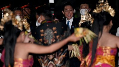 日本首相岸田文雄（中）于周日晚，抵达印尼巴厘岛的伍拉赖国际机场。（图取自法新社）
