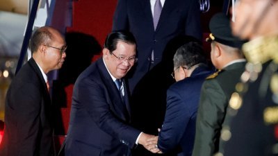 柬埔寨首相洪森（左2）周一晚抵达印尼巴厘，但因新冠病毒检测呈阳性，被迫在周二下午回国。（图取自路透社）