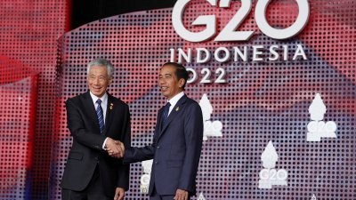 G20峰会周二开幕，作为东道主的印尼总统佐科（右）迎接陆续进场的与会领导人。图为佐科与新加坡总理李显龙握手并拍照。（图取自路透社）