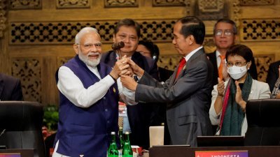 本届在印尼巴厘岛举行的G20峰会在周三落幕，作为东道主的印尼总统佐科，将锤子交给下一届轮值主席国印度的总理莫迪。（图取自路透社）