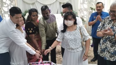 韩沙再努丁（右）在太平国民登记局为3对新人主持结婚注册仪式，而当局也安排庆结婚蛋糕和邀请3对新人共同切蛋糕。