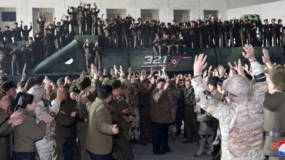 朝鲜官媒周六发布的照片显示，金正恩与一众士兵欢呼洲际弹道导弹成功试射。（图取自朝中社/路透社）