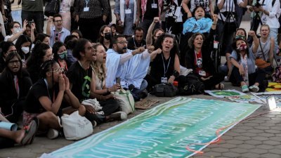 在埃及红海度假城市沙姆沙伊赫举行的第27届联合国气候变化大会期间，活动人士周五在示威游行中高喊口号，要求将全球气温上升幅度限制在工业化前摄氏1.5度内的水平。（图取自法新社）