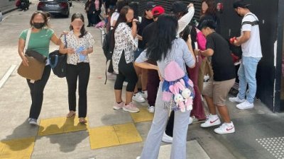 福南数码广场一带，有女佣被指在街边非法兜售食物。