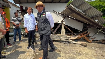 印尼总统佐科（左、白衣者）周二到地震灾区视察，他向遇难者表示哀悼，承诺向灾民提供紧急援助。他又提出，重建工作需包括兴建抗震楼房。（图取自印尼总统府/法新社）