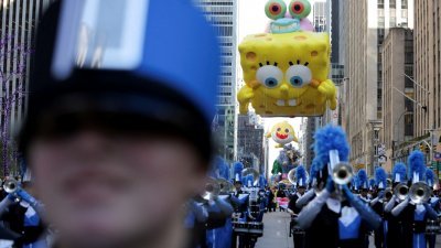 巨大的海绵宝宝造型气球在空中漂浮，纽约周四举行盛大的梅西百货游行，吸引上百万人夹道观赏。（路透社）