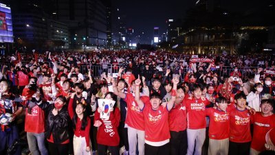韩国上万民众周四晚聚集在首尔市光化门广场，为参加世界杯的韩国国家男子足球队助威。（图取自路透社）