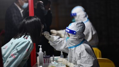 中国四川省成都市周三至周日连续5天，在18个区（市）县展开大规模新冠病毒核酸检测工作。图为工作人员在为市民进行核酸检测。（图取自中新社）