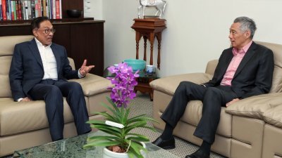 李显龙（右）祝贺安华受委马来西亚第10任首相，希望马新双方能加强两国长久且友好的双边关系。照片摄于2018年9月，安华前来新加坡出席新加坡峰会时。（取自李显龙面子书）