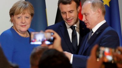 2019年12月9日，时任德国总理的默克尔（左起）在与法国总统马克龙和俄罗斯总统普京，在法国巴黎举行诺曼底式峰会后，一同出席联合新闻发布会。（路透社档案照）