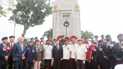 曹观友（前排左7）周日早上出席旧关仔角阵亡战士纪念碑前举行的英雄纪念日仪式。