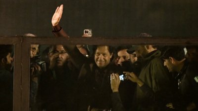 在巴基斯坦首都伊斯兰堡附近的拉瓦尔品第市，前总理伊姆兰汗（中）在遇袭3周后首次公开露面，他抵达现场时向支持者挥手致意。（图取自法新社）